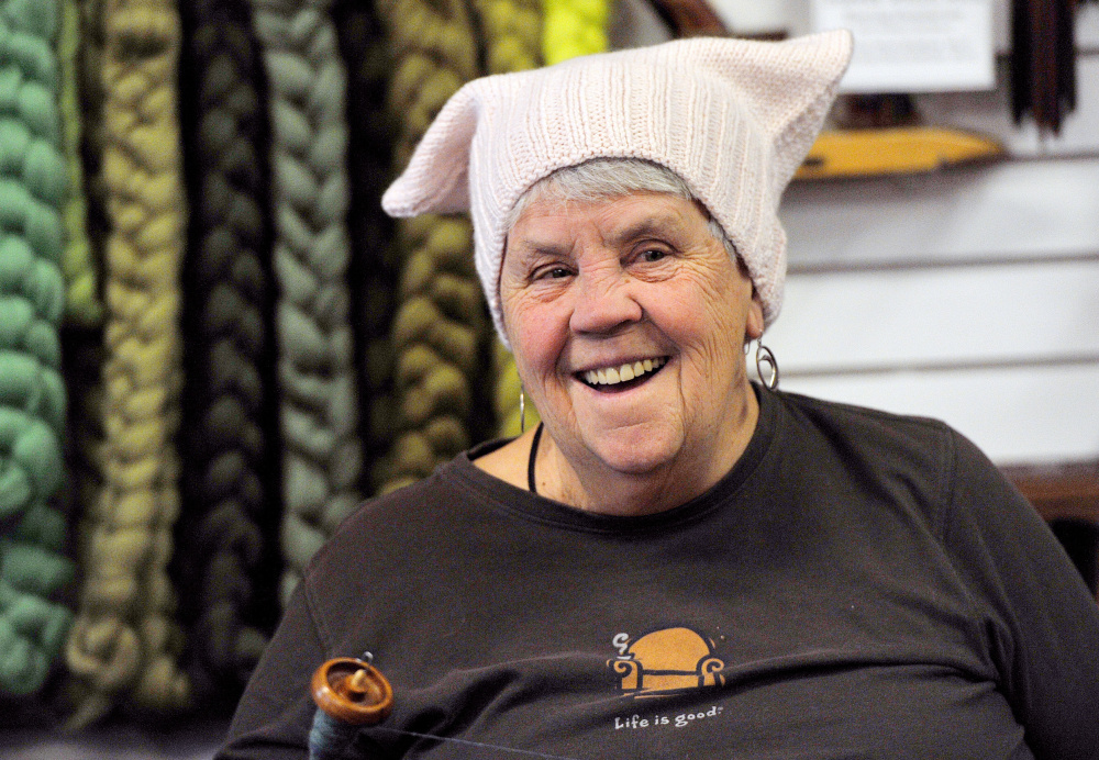 Wearing a hat made for the Pussyhat Project, Linda Healey of Kennebunk laughs with others gathered for a spinning group at PortFiber on Thursday. Craftspeople are knitting the hats to be worn at the Women's March on Washington on Jan. 21.