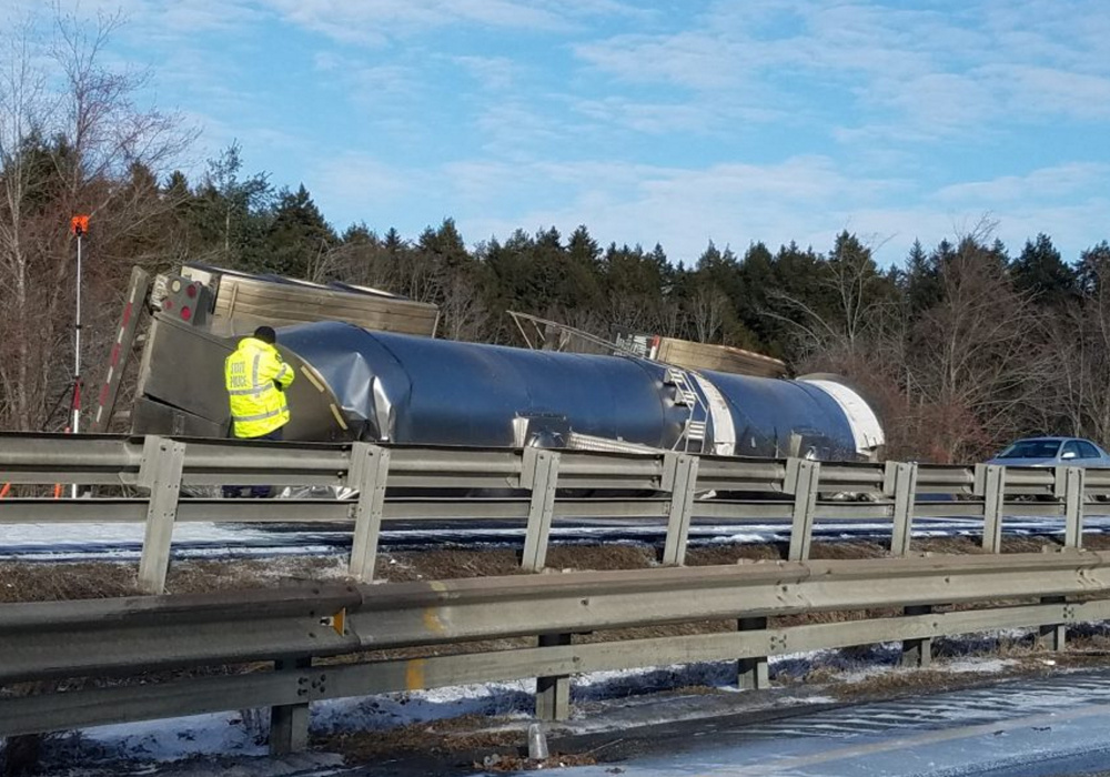 A tanker truck carrying milk lies on its side after a fatal crash on I-295 in Freeport on Saturday.