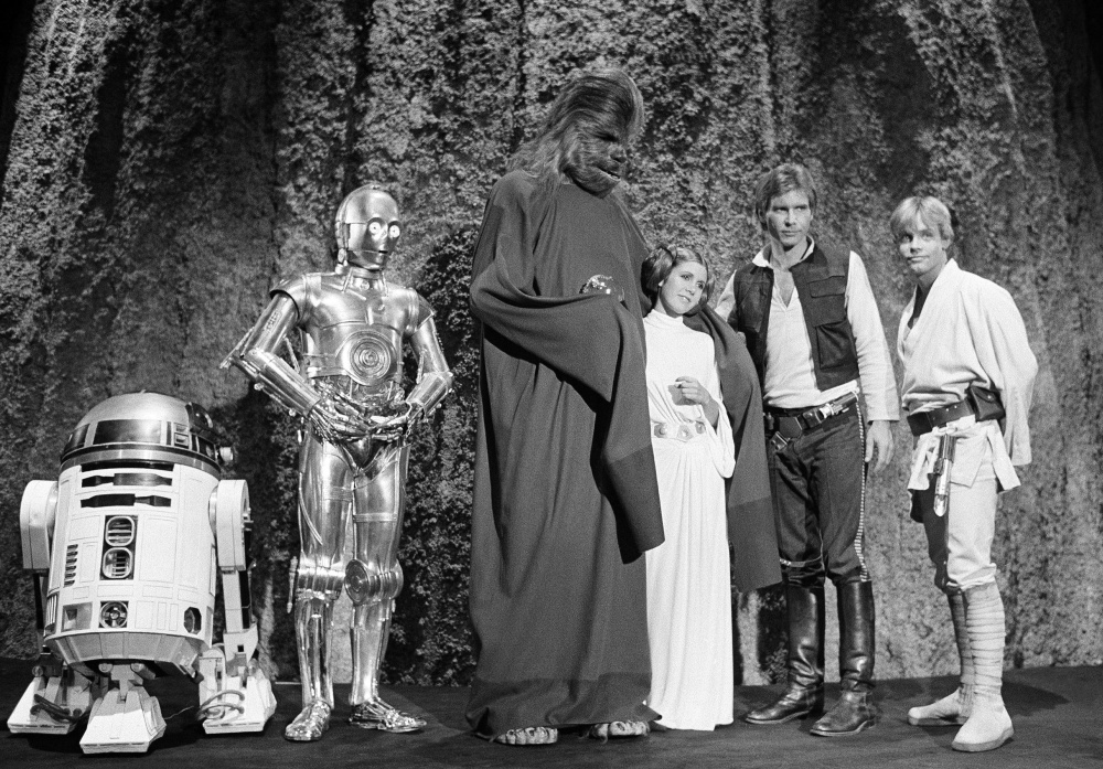 FILE - In this Nov. 13, 1978 file photo, shows, from left, Kenny Baker, Anthony Daniels, Peter Mayhew, Carrie Fisher, Harrison Ford, and Mark Hamill during the filming of the CBS-TV special "The Star Wars Holiday" in Los Angeles. On Tuesday, Dec. 27, 2016, a publicist says Fisher has died at the age of 60. (AP Photo/George Brich, File)