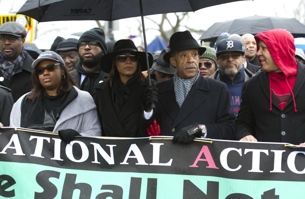 The Rev. Al Sharpton, center, and civil rights advocates march to honor the Rev. Martin Luther King Jr. in Washington, D.C., on Saturday. Official ceremonies are Monday.
