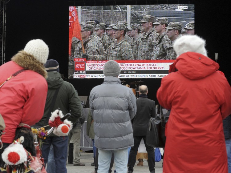People watch a live broadcast of the welcoming ceremony for U.S. troops in Warsaw on Saturday. The Polish government organized events across the country to mark the arrival of the Americans from Fort Carson, Colorado.