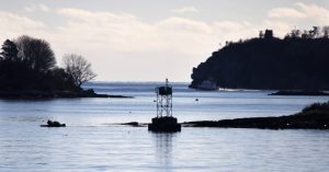 A navigation beacon stands on the northern end of House Island, while Peaks Island, left, and Cushing Island, top right, are silhouetted in the background. The private property on House Island has changed ownership. 
