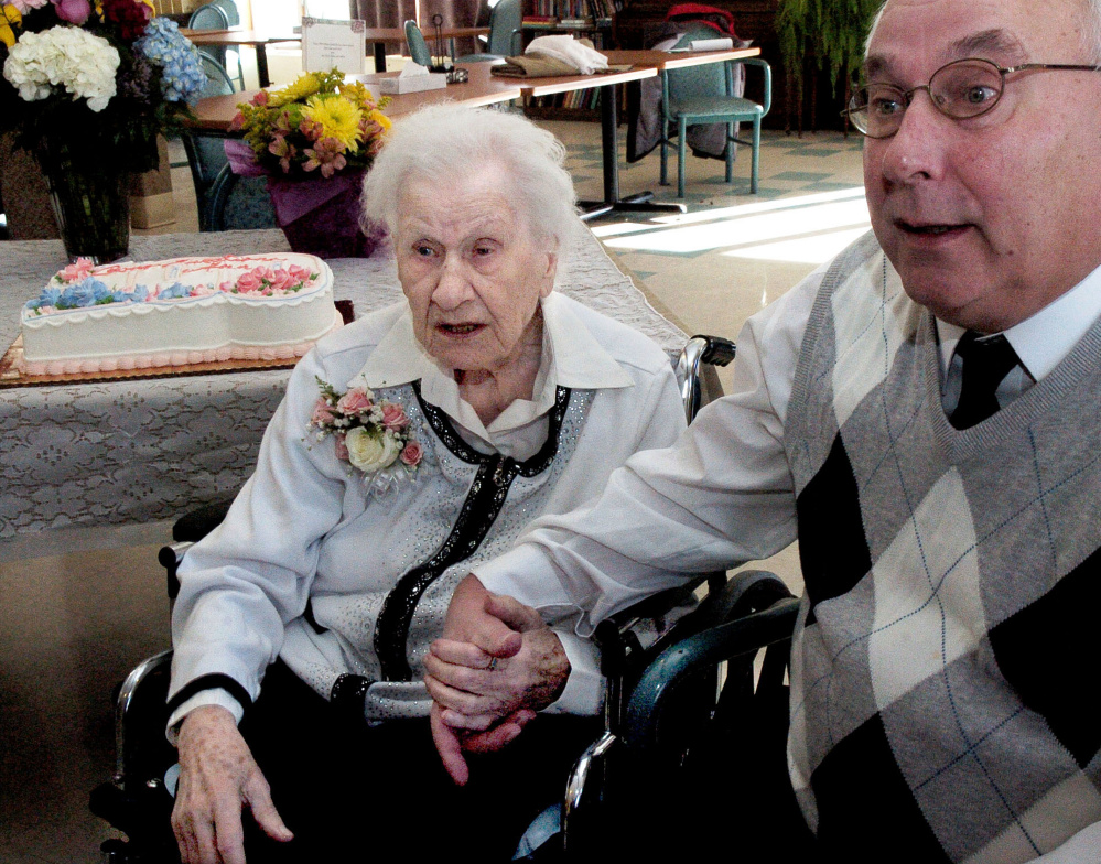 Ann Labin and her son David hold hands while talking about her long life prior to her 100th birthday party at the Maple Crest Living Center in Madison on Monday.