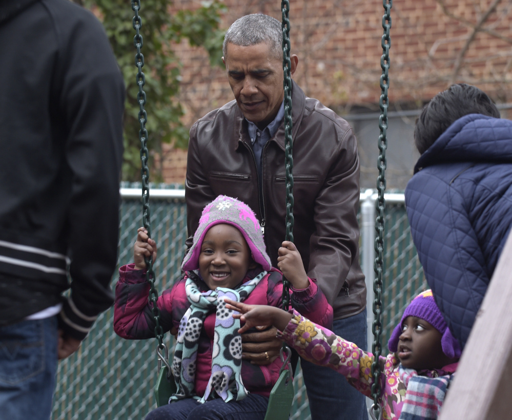 President Obama pushes kids on the swings as they visit "Malia and Sasha's Castle" that the Obamas donated to the Jobs Have Priority Naylor Road Family Shelter.
