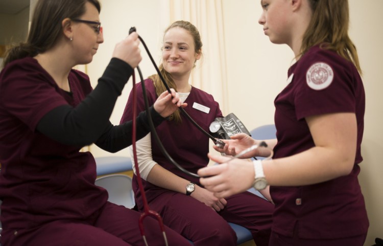 From left, Sam Lariviere, Breanna Longstaff and April Cummings check blood pressure during a class at Saint Joseph's College. As the number of retiring nurses climbs dramatically, a Harold Alfond Foundation grant will help the school expand its nursing program.