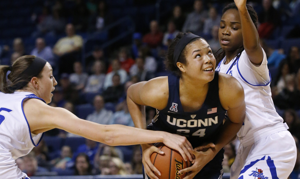 Napheesa Collier of Connecticut protects the ball as Liesl Spoerl, left, and Shug Dickson of Tulsa defend during the second quarter of UConn's 98-58 victory Tuesday night. The Huskies have won 92 consecutive games.