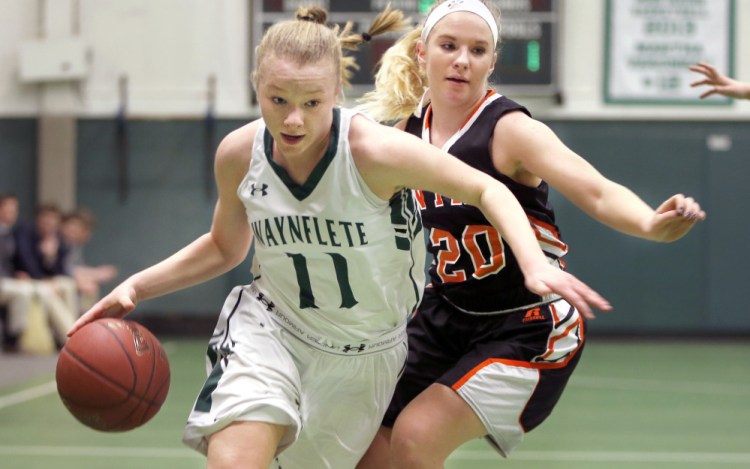 Lydia Giguere of Waynflete drives to the basket Tuesday while defended by Lindsay Tufts of North Yarmouth Academy during Waynflete's 45-40 victory at home.