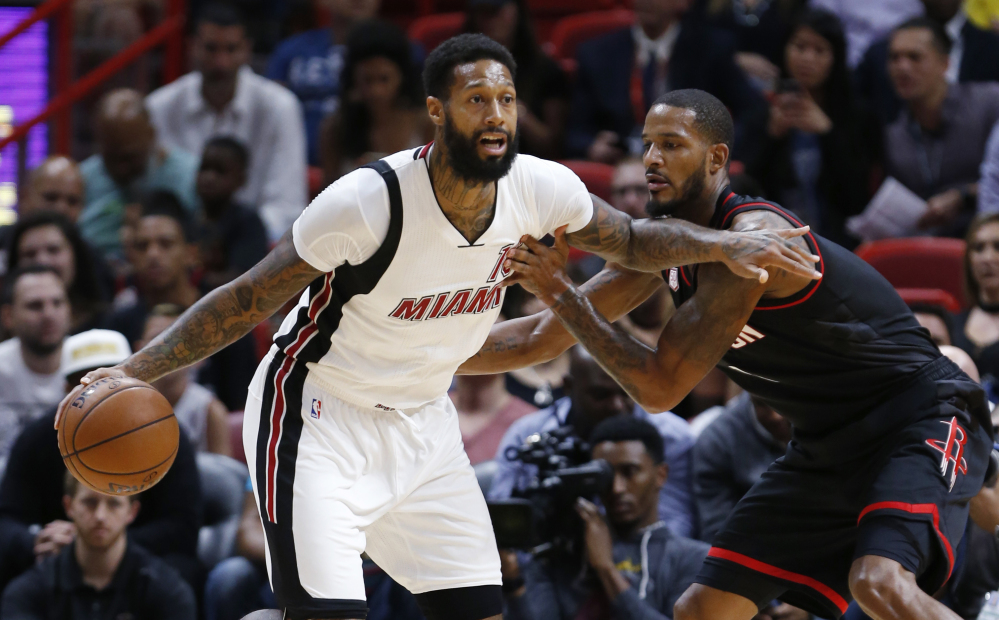 James Johnson of the Miami Heat drives past Trevor Ariza of the Houston Rockets during the first half of Miami's 109-103 victory at home Tuesday night.