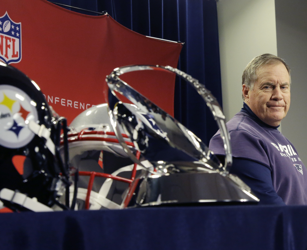 Patriots Coach Bill Belichick glances at the Lamar Hunt Trophy that he hopes to hold aloft Sunday night. It goes to the winner of the AFC title game.
