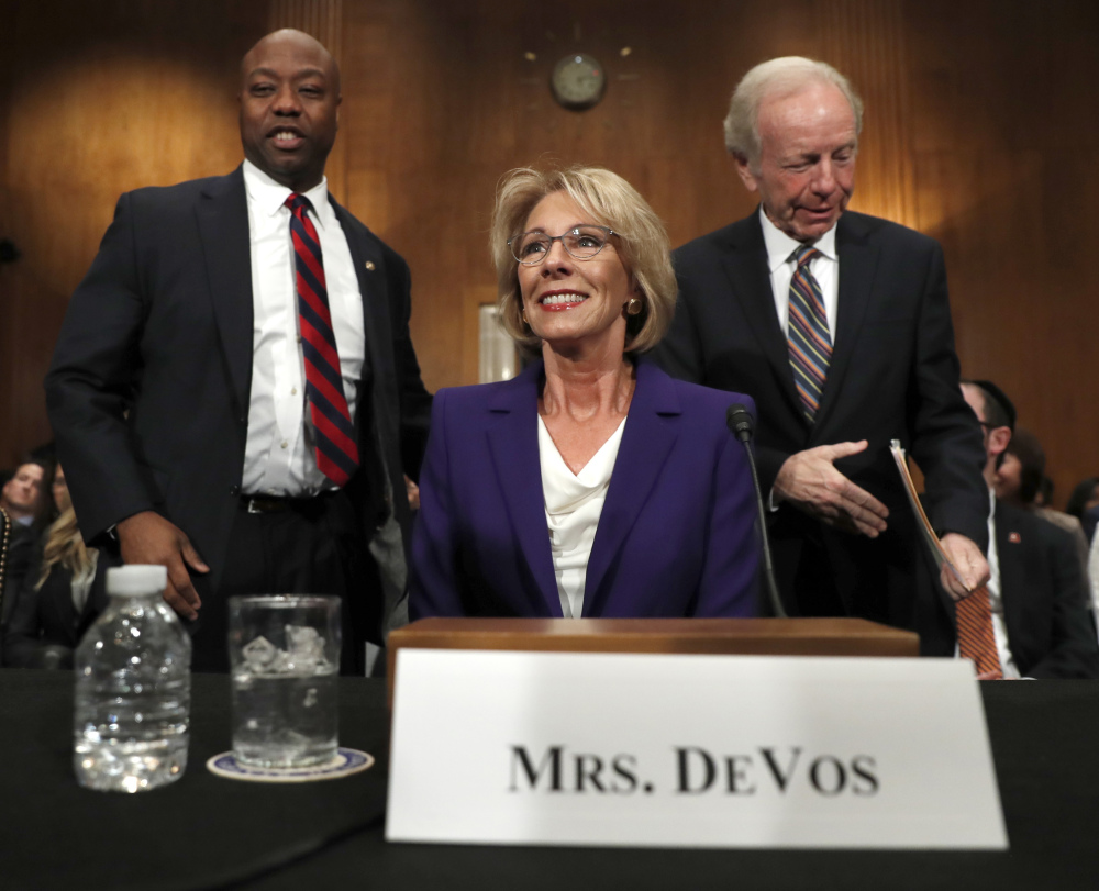 Education Secretary-designate Betsy DeVos arrives with former Sen. Joe Lieberman and Sen. Tim Scott, R-S.C., before testifying on Capitol Hill in Washington, Tuesday, Jan. 17, 2017, at her confirmation hearing before the Senate Health, Education, Labor and Pensions Committee. (AP Photo/Carolyn Kaster)