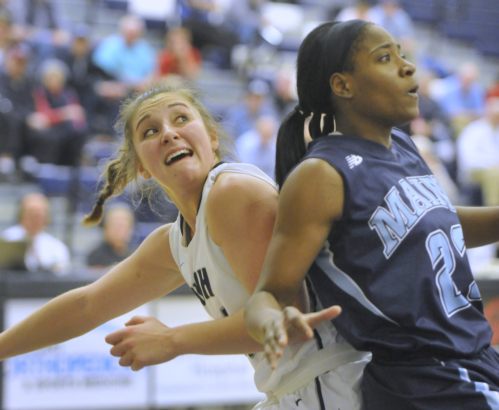 Olivia Healy, left, of the University of New Hampshire battles Tanesha Sutton of Maine during Thursday night's game at Durham, N.H. UNH won, 60-54. (John Ewing/Staff Photographer)