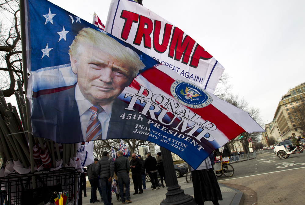 Flags adorned with Donald Trump's visage are for sale Thursday along the Inaugural Parade route on Pennsylvania Avenue in Washington. Inauguration events kicked off Thursday with a concert headlined by Toby Keith at the Lincoln Memorial.