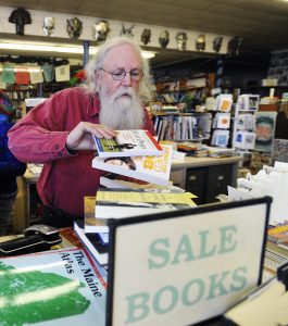 Longtime Maine bookseller and poet Gary Lawless works behind the counter at Gulf of Maine Books in Brunswick. 