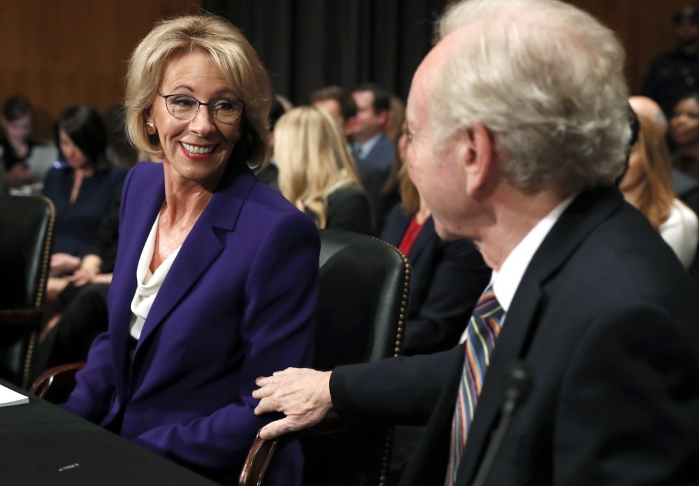 Education Secretary-designate Betsy DeVos talks to Joe Lieberman at her confirmation hearing on Tuesday. Freshman Sen. Maggie Hassan of N.H. tossed her some tough questions.