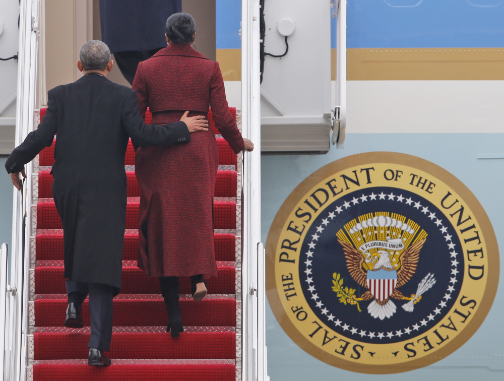 Former President Obama and his wife, Michelle, board an Air Force jet as they depart Andrews Air Force base on Friday.