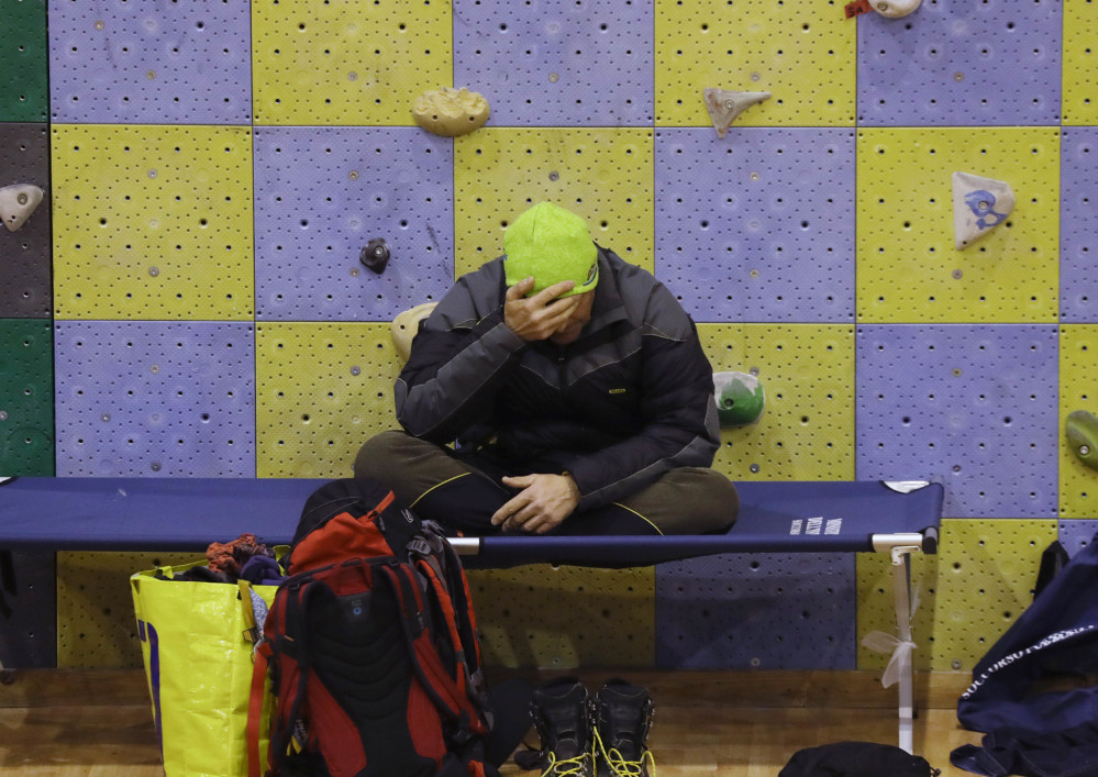 A rescuer rests in a sports palace turned into a coordination center Saturday in Penne, Italy. An official said 23 people were still missing but called that number "provisional."