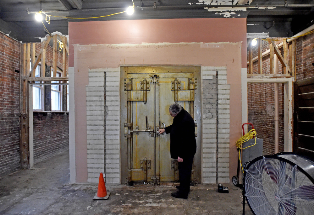 Paul Ureneck, director of commercial real estate for Colby College, inspects the 1902-era safe from the former Waterville Savings Bank that first occupied the former Hains Building, which is being renovated as part of a $5 million project.