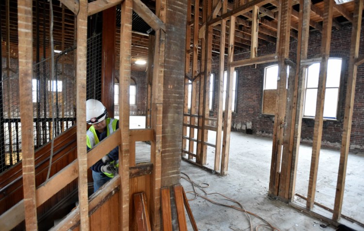 Connie Damboise and Ken Theriault work on the top floor of the former Hains Building on Main Street in Waterville on Friday. The building at 173 Main St. is being renovated as part of a $5 million project.