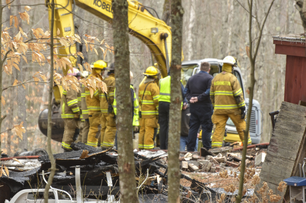 Firefighters from Washington and Liberty survey the damage Monday at the fatal fire on Cattle Pond Road in Washington.