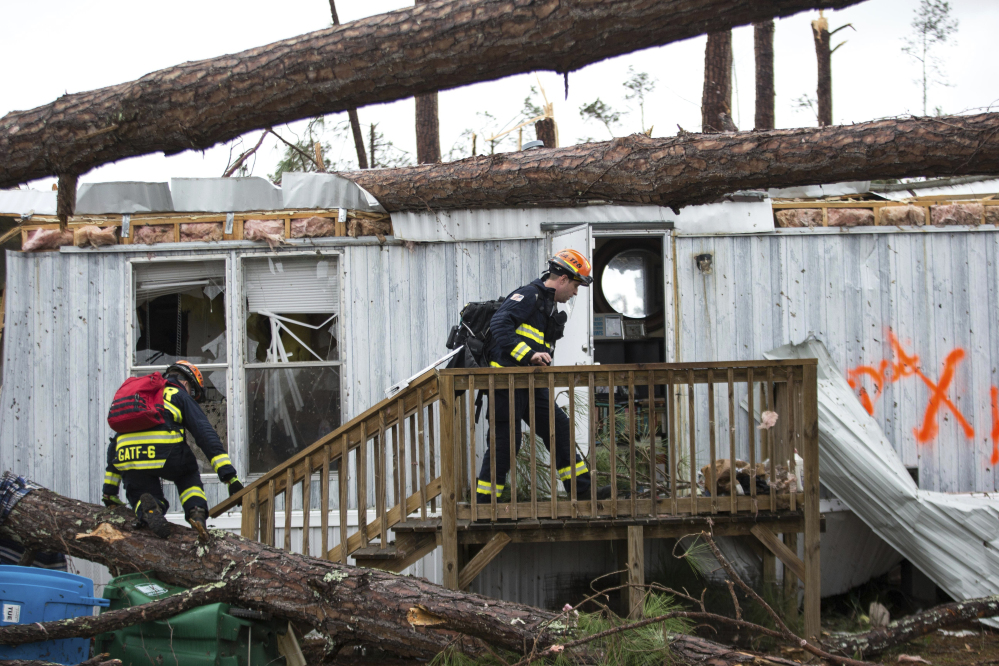 Rescue workers prepare to enter a mobile home Monday to search for survivors at Big Pine Estates after it was damaged by a tornado in Albany, Ga. Fire and rescue crews were searching through the debris Monday, looking for people who might have become trapped when the storm came through.