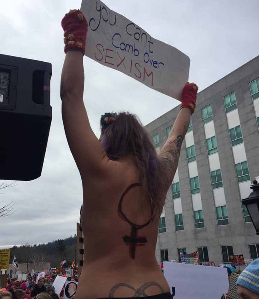 When Capitol Police tried to get this topless woman to step down from a pillar Saturday in Augusta, the officer was bitten on the hand by another woman, police said.