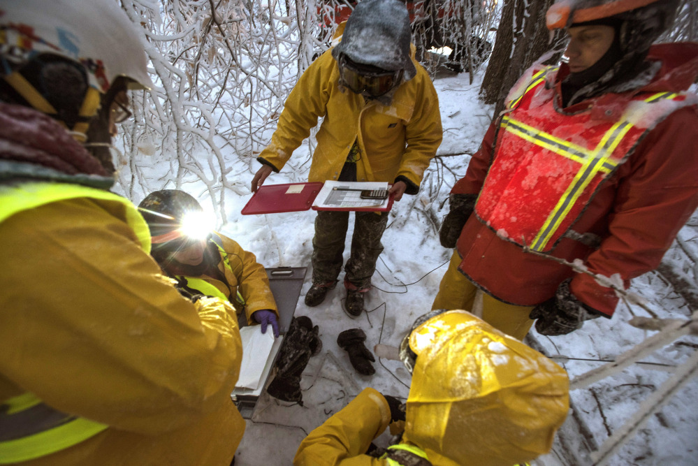Researchers gather to measure ice accumulation on wooden collectors in the Hubbard Brook Experimental Forest in Woodstock, New Hampshire this month. Scientists have been creating ice storms there to help understand the effects of ice on northern forests.