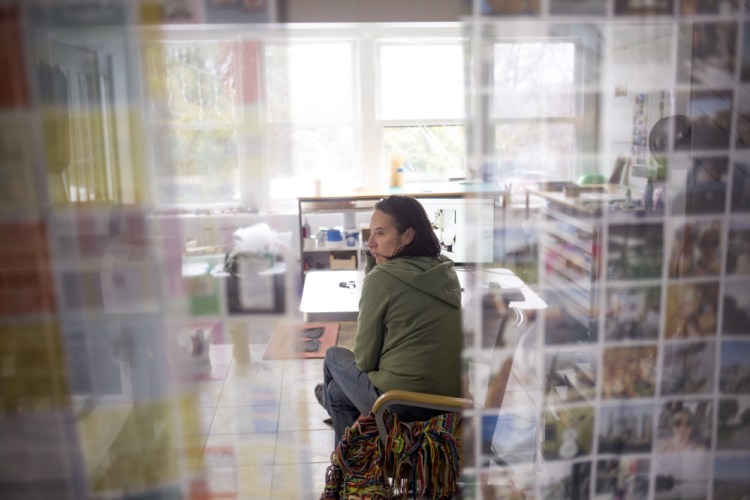 Tanja Hollander is surrounded by prints of her photos in her studio at her home in Auburn as she prepares for the opening of her exhibition "Are You Really My Friend" on Feb. 18 at Mass MoCA in North Adams, Mass. Hollander spent five years photographing her Facebook friends around the world.