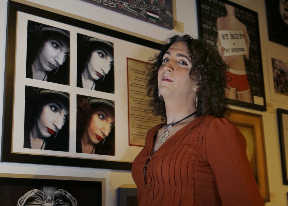 Artist Chloe LaCasse poses next to her self-portraits and poetry entitled "Red Lips," part of the group exhibit "This is What TRANS Feels Like" at The Wrong Brain Art Collective in Dover, N.H. The exhibit runs through Feb. 14.