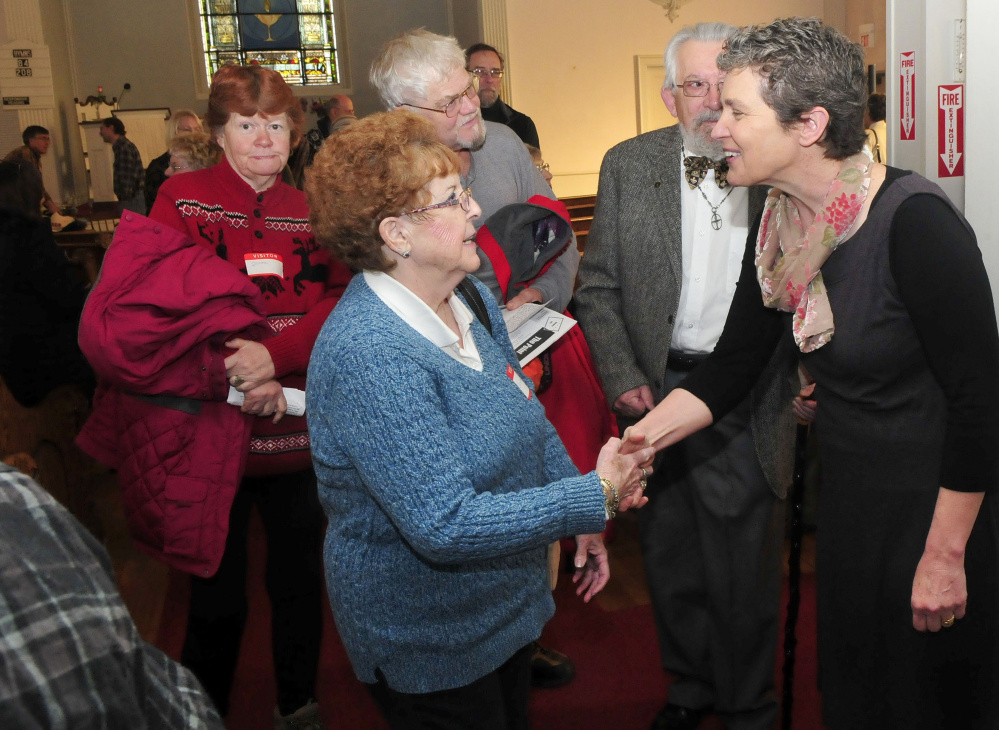 Author Kate Braestrup, right, who is also a chaplain and game warden, greets Coreine Fletcher of Palmyra, following Braestrup's remarks on rights and civility at the Universalist-Unitarian Church in Waterville on Sunday.