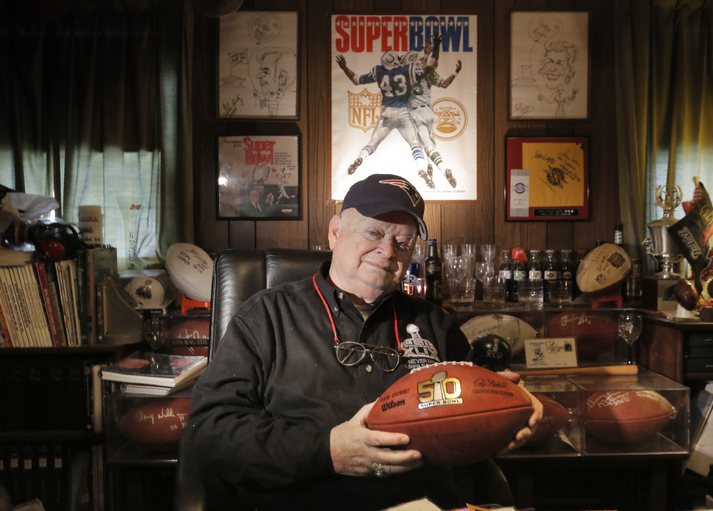 Patriots fan Don Crisman holds a Super Bowl 50 football at his Kennebunk home, which features a room dedicated to sports memorabilia, including items from his 50 trips to the Super Bowl.