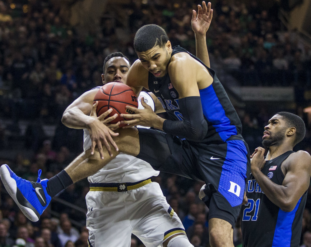Duke's Jayson Tatum, center, grabs a rebound from Notre Dame's Bonzie Colson, left, and teammate Amile Jefferson during an 84-74 Blue Devils' win Monday at South Bend, Ind.