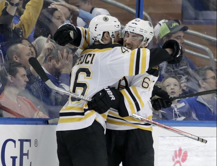 Boston Bruins center David Krejci, 46, hugs teammate left wing Brad Marchand, 63, after Krejci scored against the Tampa Bay Lightning during the second period Tuesday.
