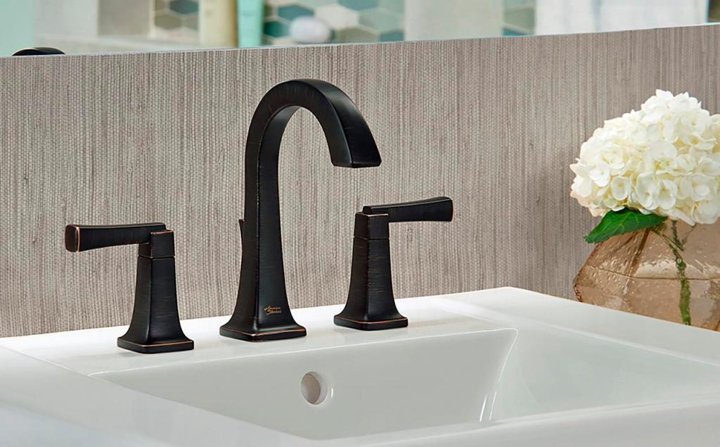 The distinctive high-arc American Standard Townsend widespread bathroom sink faucet with accessible lever handles is featured here in a dramatic Legacy Bronze finish.