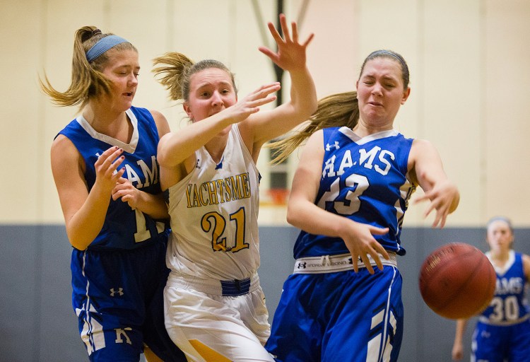 Falmouth forward Hadley Wiggins and Kennebunk forward Madison Lux, right, battle beneath the boards for a rebound during Monday's game. Kennebunk forward Alaina Schatzabel is at left.