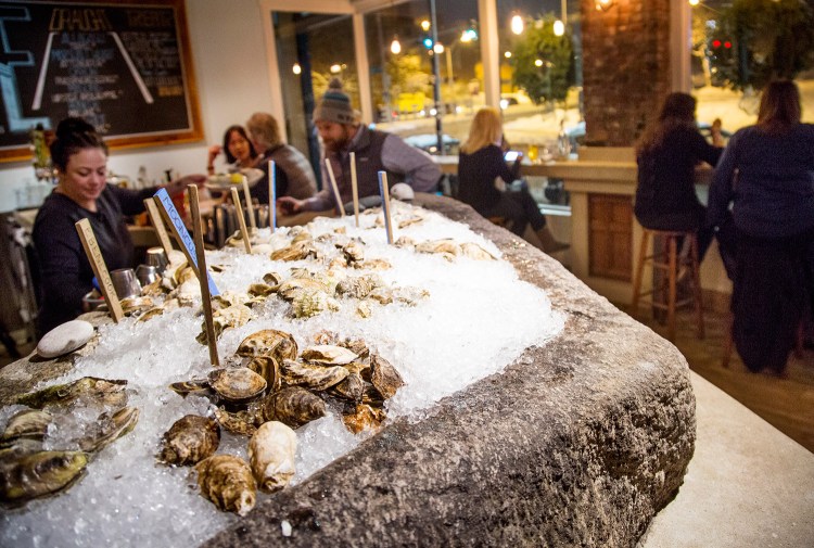 A selection of oysters chill in the ice-filled well of large block of granite at Eventide restaurant in Portland. 
