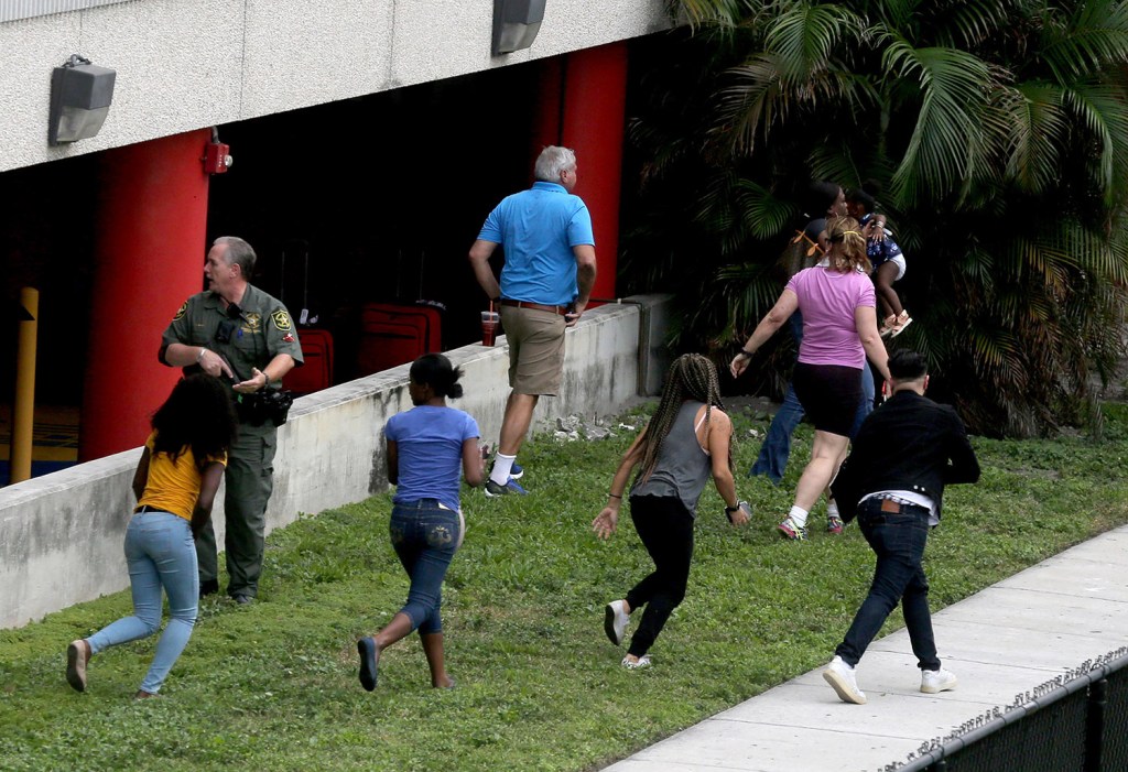 People flee the area outside the Fort Lauderdale airport after a man opened fire in the baggage claim area Friday. The attack sent panicked passengers running out of the terminal and onto the tarmac.
Mike Stocker/South Florida Sun-Sentinel via AP