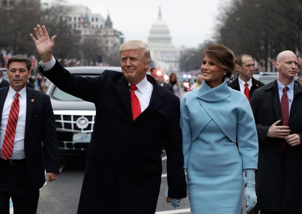 President Donald Trump waves as he walks with first lady Melania Trump during the inauguration parade on Pennsylvania Avenue in Washington on Friday.