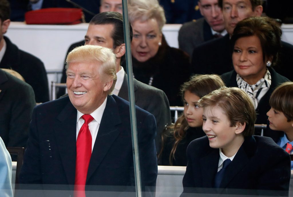 President Donald Trump smiles with his son Barron as they view the 58th Presidential Inauguration parade in Washington on Friday.