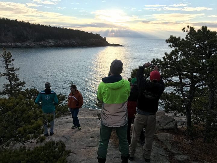 Gary Allen's friends admire the "RESIST" sign they wrote from the cliffs near Sand Beach in Acadia National Park on Sunday.