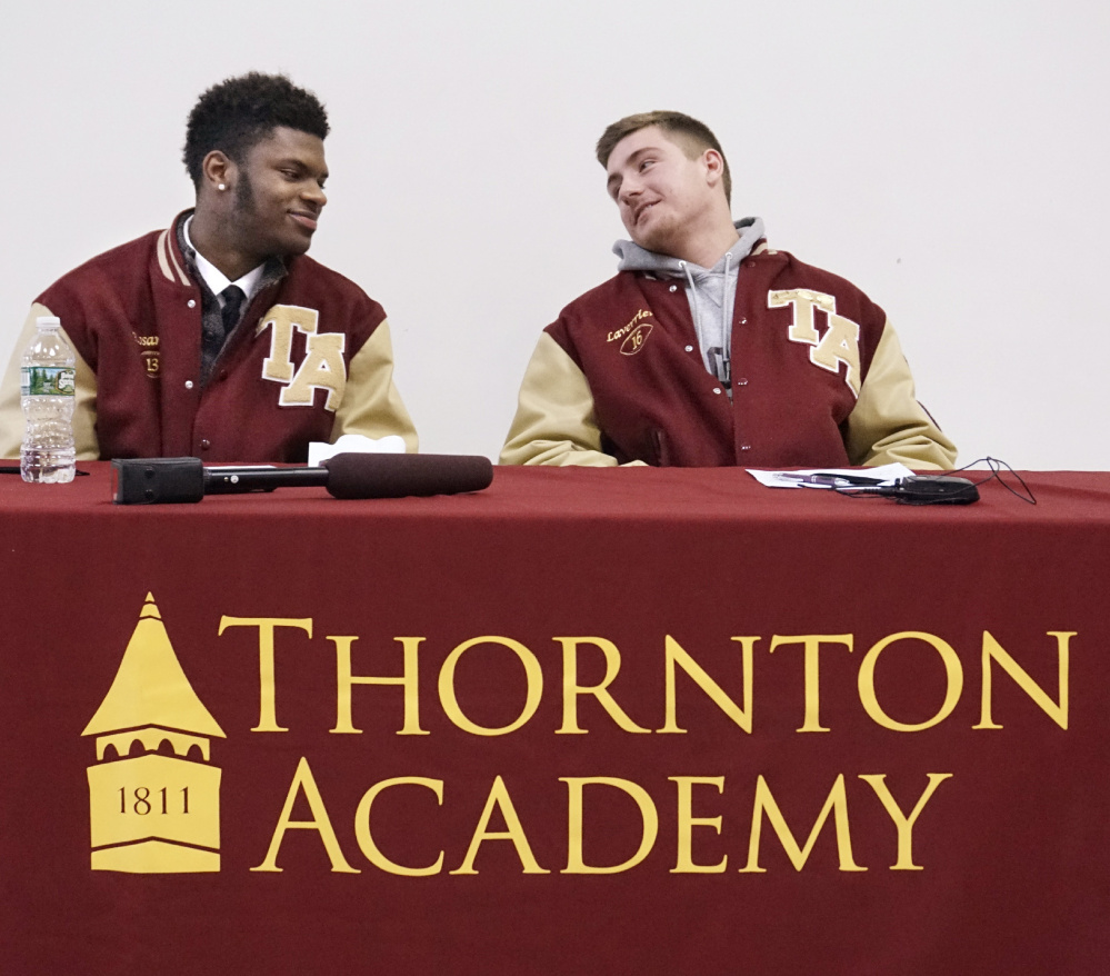 Johnny Rosario, left, and Michael Laverriere share the podium at Thornton Academy after signing letters of intent to play football at UMaine.