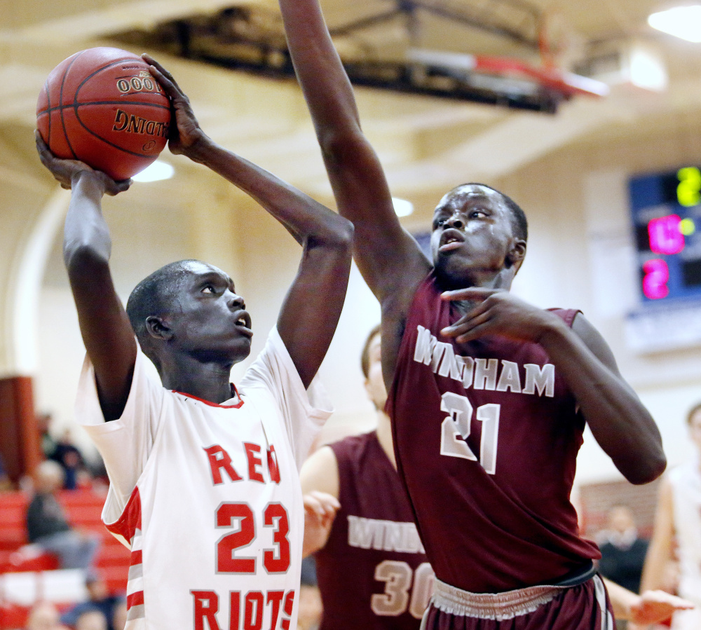 Ruay Bol, a senior for South Portland, drives against his brother, Dierhow Bol, a Windham sophomore, during their game Tuesday. South Portland won, 62-53.