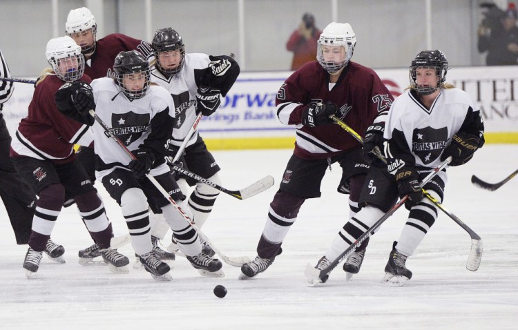 Greely and St. Dominic players battle for a loose puck during Thursday's game in Auburn, They are, from left, Molly Horton of Greely, Bugsy Hammerton and Kristina Cornelio of St. Dominic, Kylie Rogers of Greely and Avery Lutrzykowski of St. Dominic. The Saints won, 3-2.