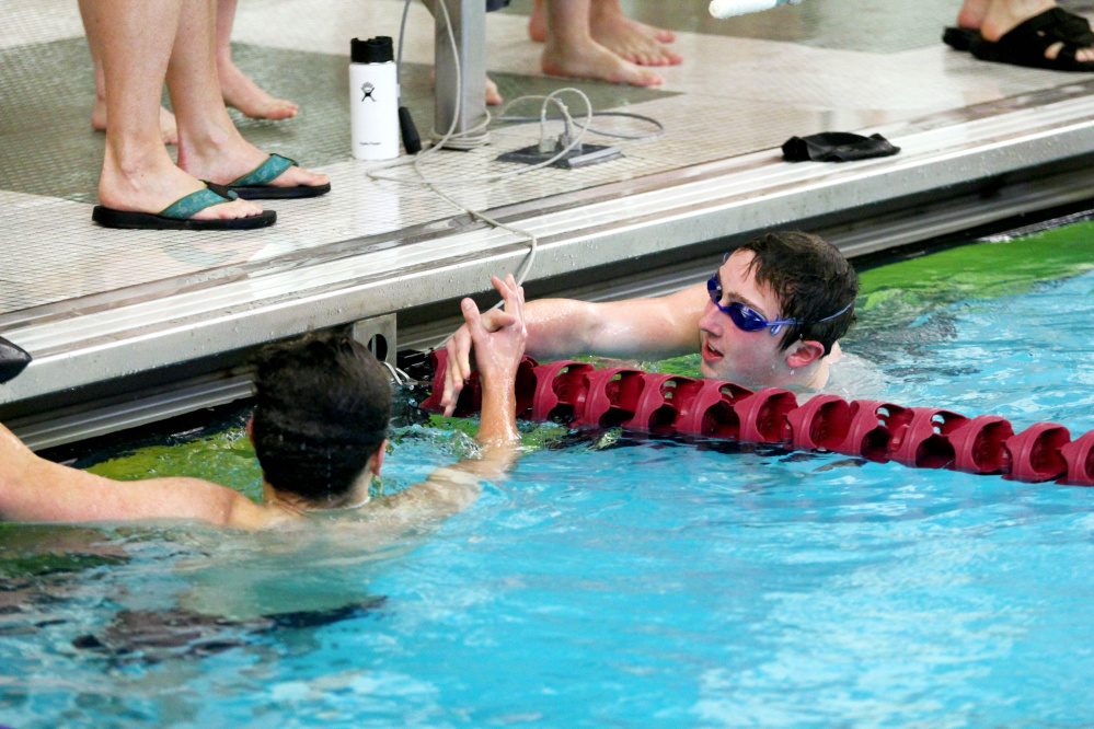 Waterville/Winslow's John Reisert is congratulated by Mt. Ararat's Deven Hoskins after winning the 500-yard freestyle at the Kennebec Valley Athletic Conference Class A meet Saturday in Bath.