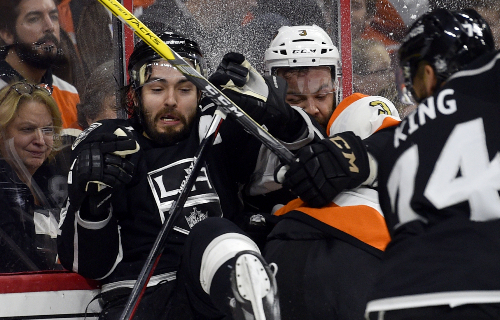 Philadelphia's Radko Gudas, right, checks Los Angeles' Drew Doughty into the boards during the third period of the Kings' 1-0 win in overtime Saturday in Philadelphia. Los Angeles won its fifth straight game and goalie Peter Budaj posted his NHL-leading seventh shutout.