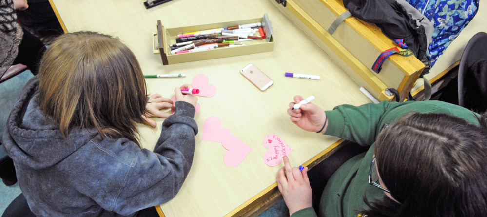 Morgan Ross, left, and Rose Fendley make Valentine's Day cards to be distributed at the Maine Veterans' Home in Augusta during a Jobs for Maine's Graduates class Friday at Hall-Dale High School in Farmingdale.