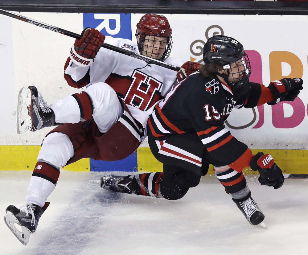 Harvard's Michael Floodstrand, left, is tripped up by Northeastern's Lincoln Griffin during the second period of Harvard's 4-3 win in a semifinal game of the Beanpot tournament Monday at Boston.