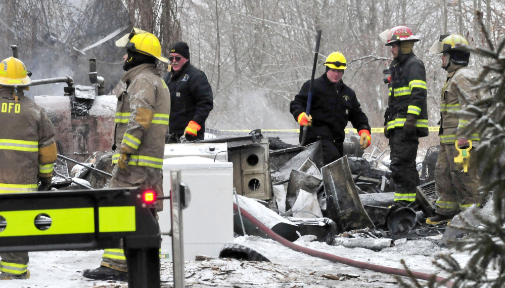 State officials and local firefighters examine the section of an apartment building on Square Road in Palmyra where the bodies of two tenants were recovered Tuesday.