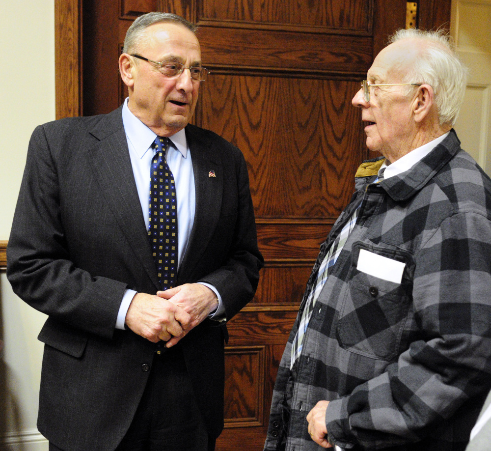 Gov. Paul LePage chats with Richard Sukeforth at a reception Tuesday night. The governor is proposing legislation to keep seniors like Sukeforth in their homes.