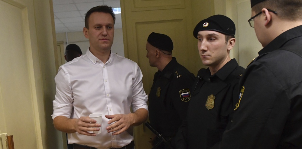 Russian opposition leader Alexei Navalny, left, enters a courtroom for a retrial Wednesday in Kirov.