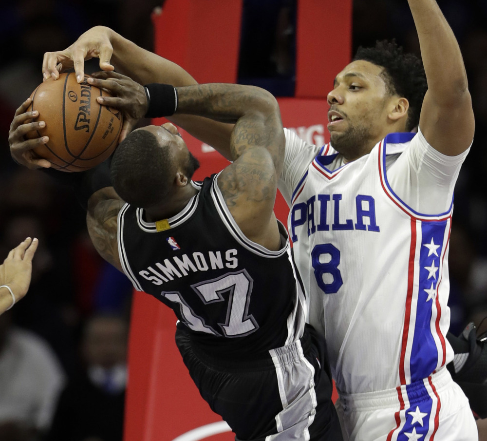 Philadelphia 76ers' Jahlil Okafor, right, blocks a shot by San Antonio Spurs' Jonathon Simmons during the first half of an NBA basketball game, Wednesday, Feb. 8, 2017, in Philadelphia. ()